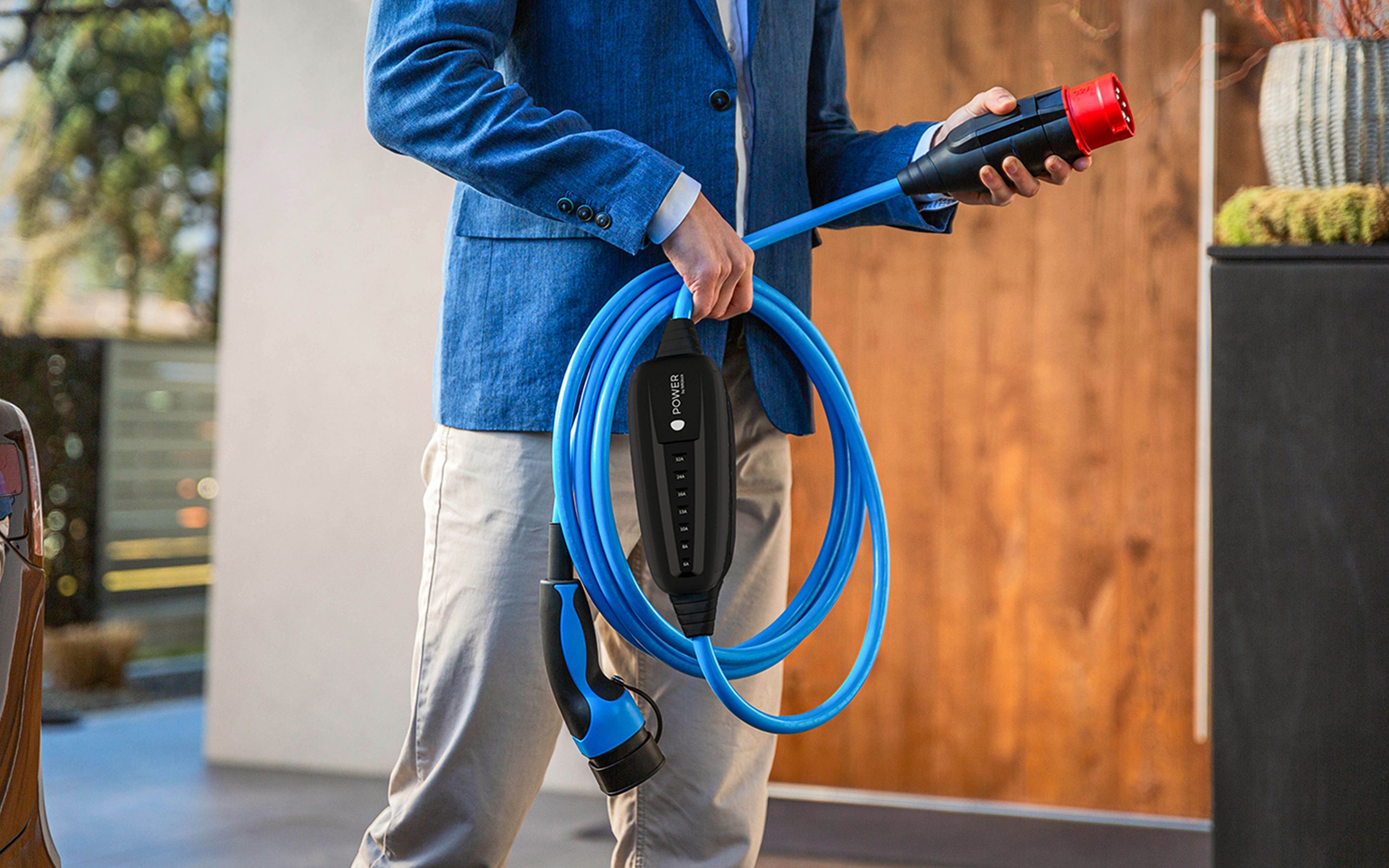 Un bărbat ține priza unui cablu în mână