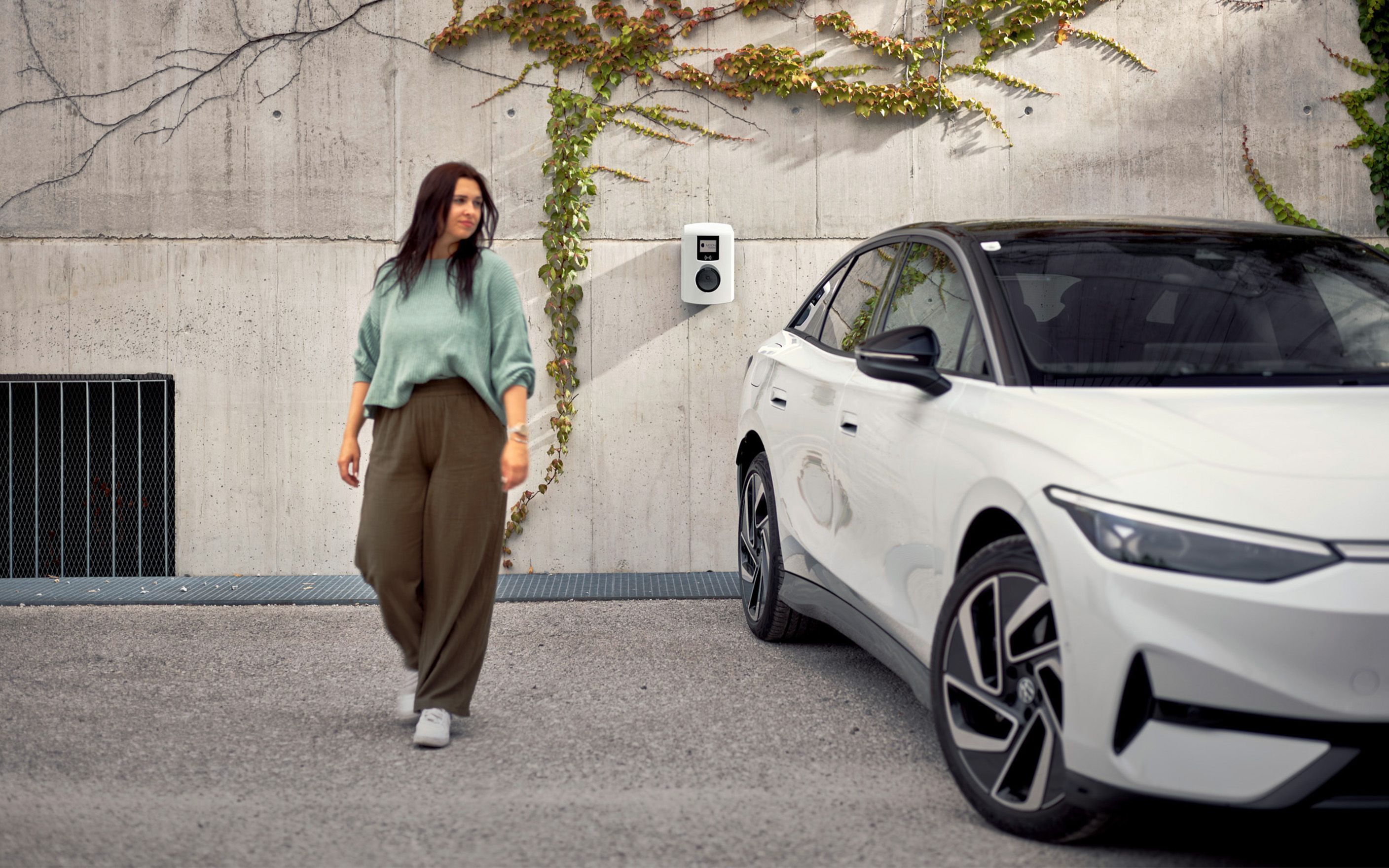 Femeie mergând lângă o mașină albă