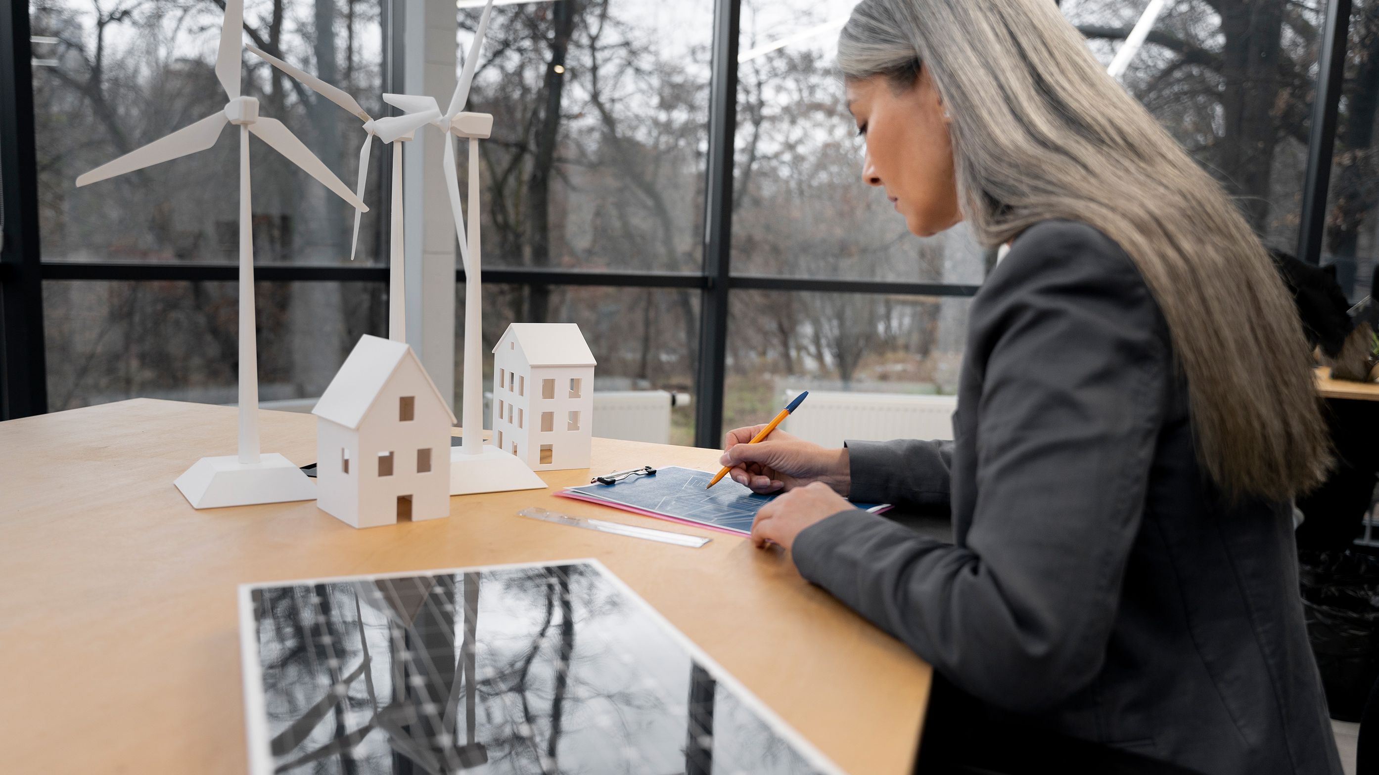 O femeie stă la o masă și notează ceva