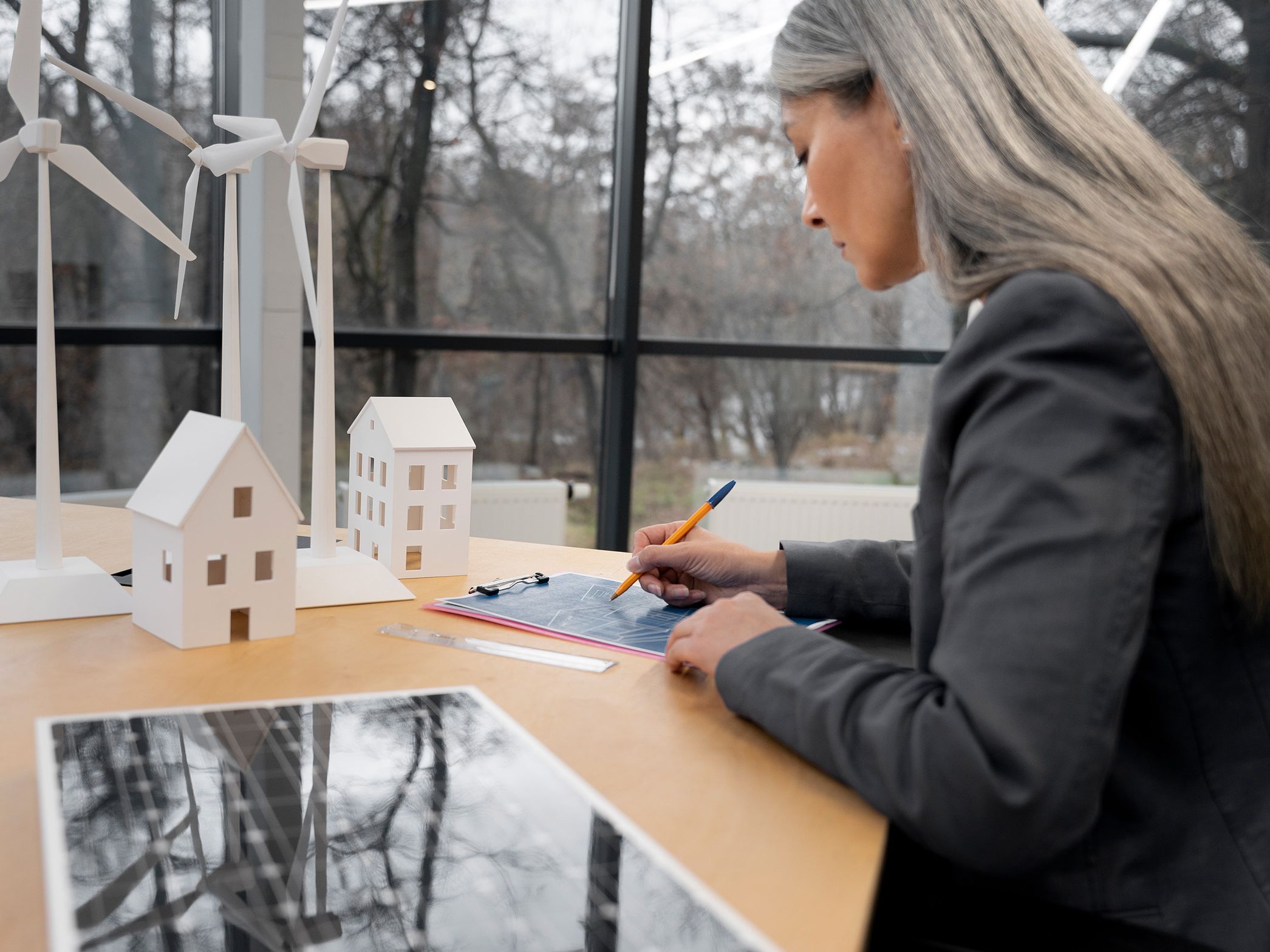 O femeie stă la o masă și notează ceva