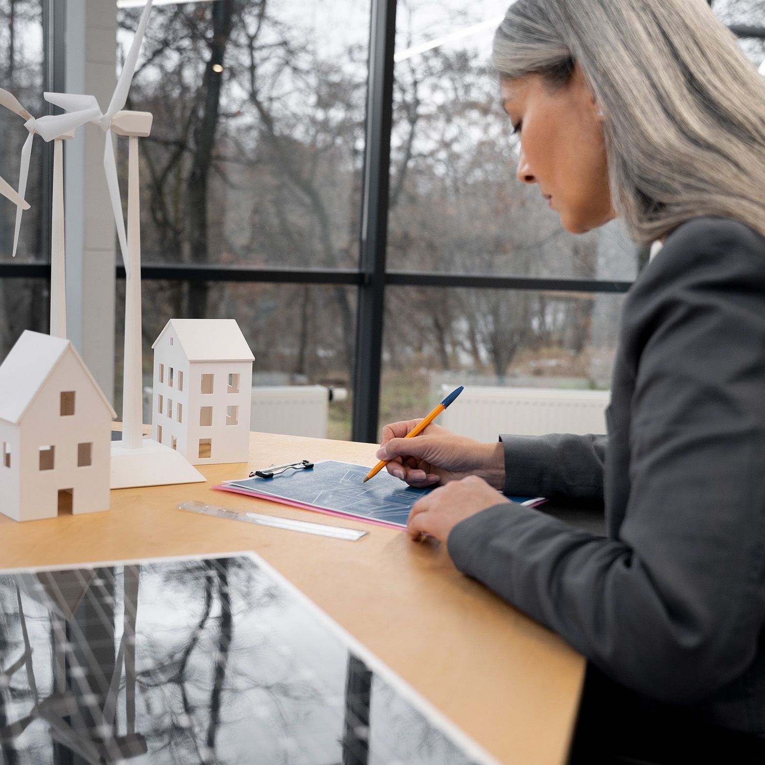 O femeie stă la o masă și notează ceva