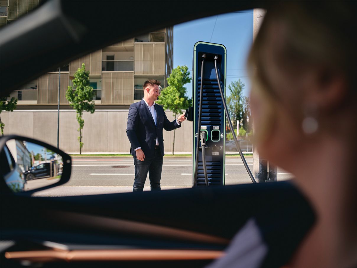 Un bărbat ține cardul la o stație de încărcare