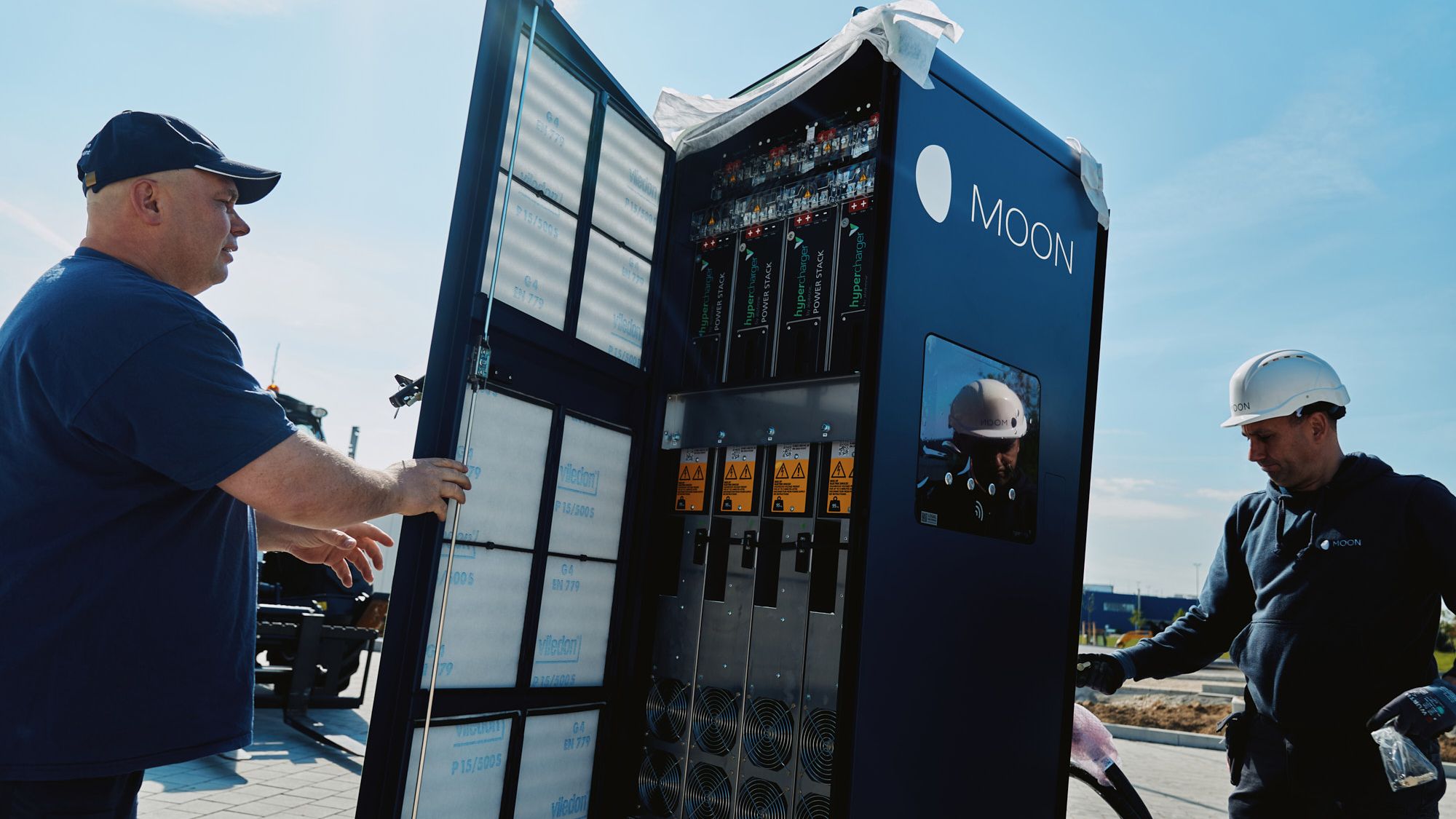 two men carry out the installation of a POWER Charger fast charging station