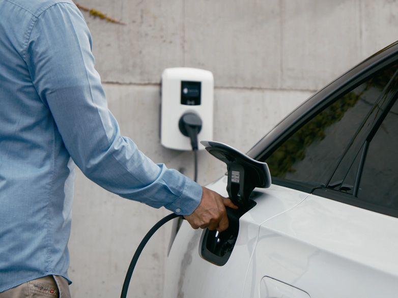 Persoană care încarcă mașina la un wallbox