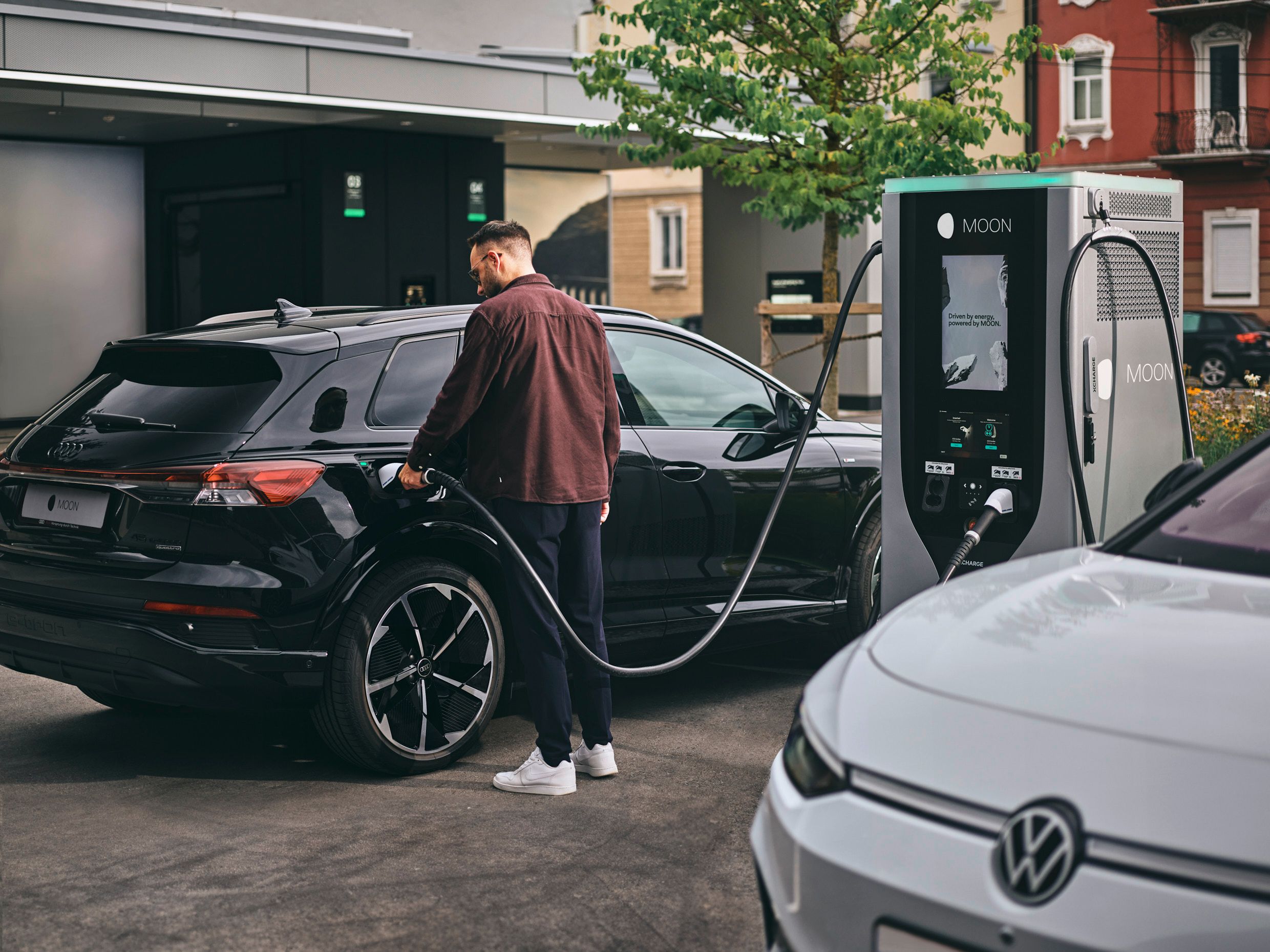 Person charging electric car at a fast charging station