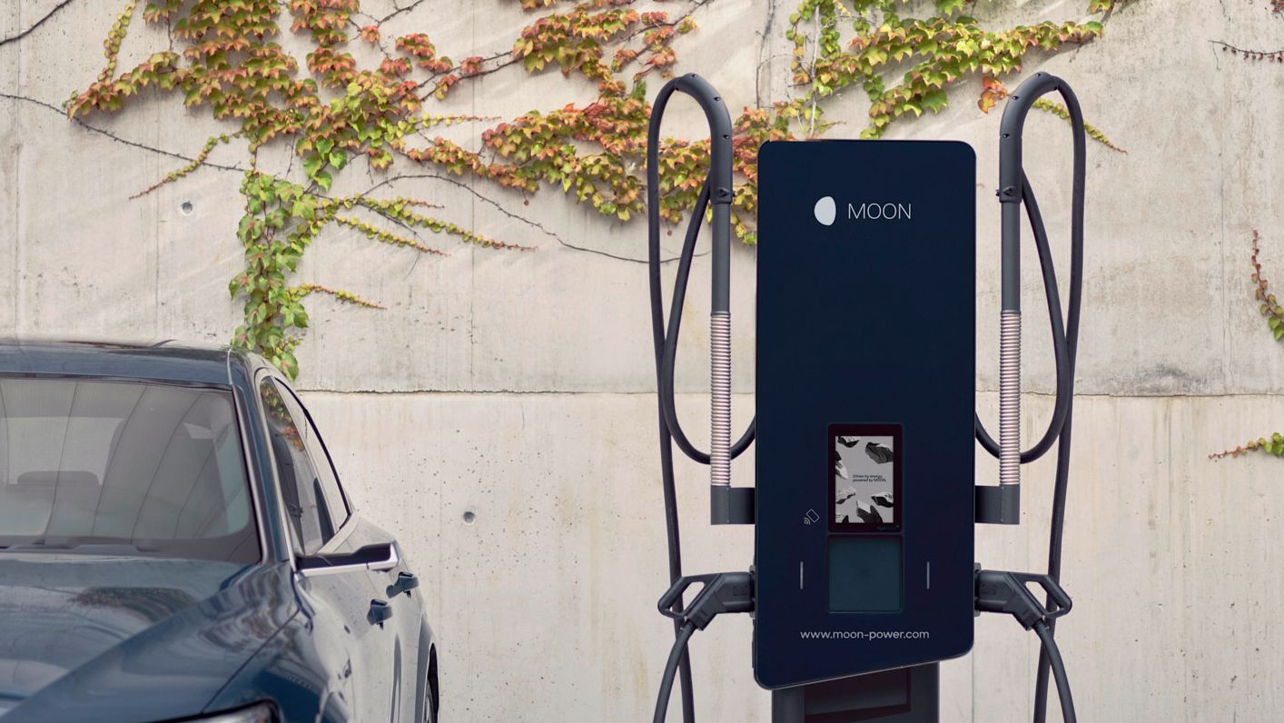 Mașina este parcată lângă o stație de încărcare