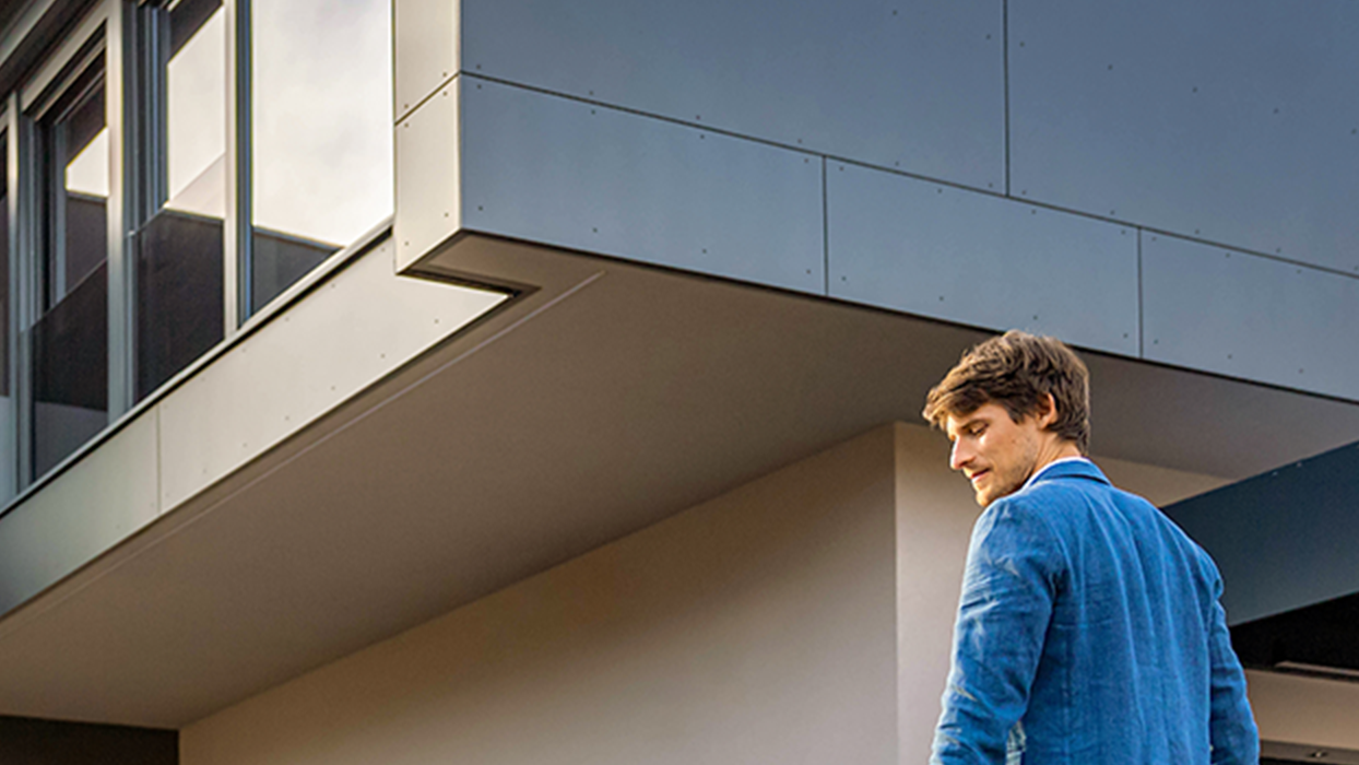 O persoană merge spre o mașină cu cablu în mână