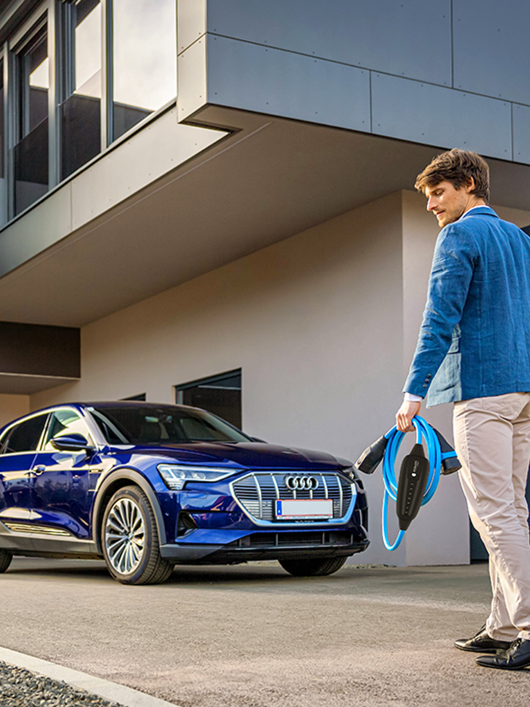 O persoană merge spre o mașină cu cablu în mână