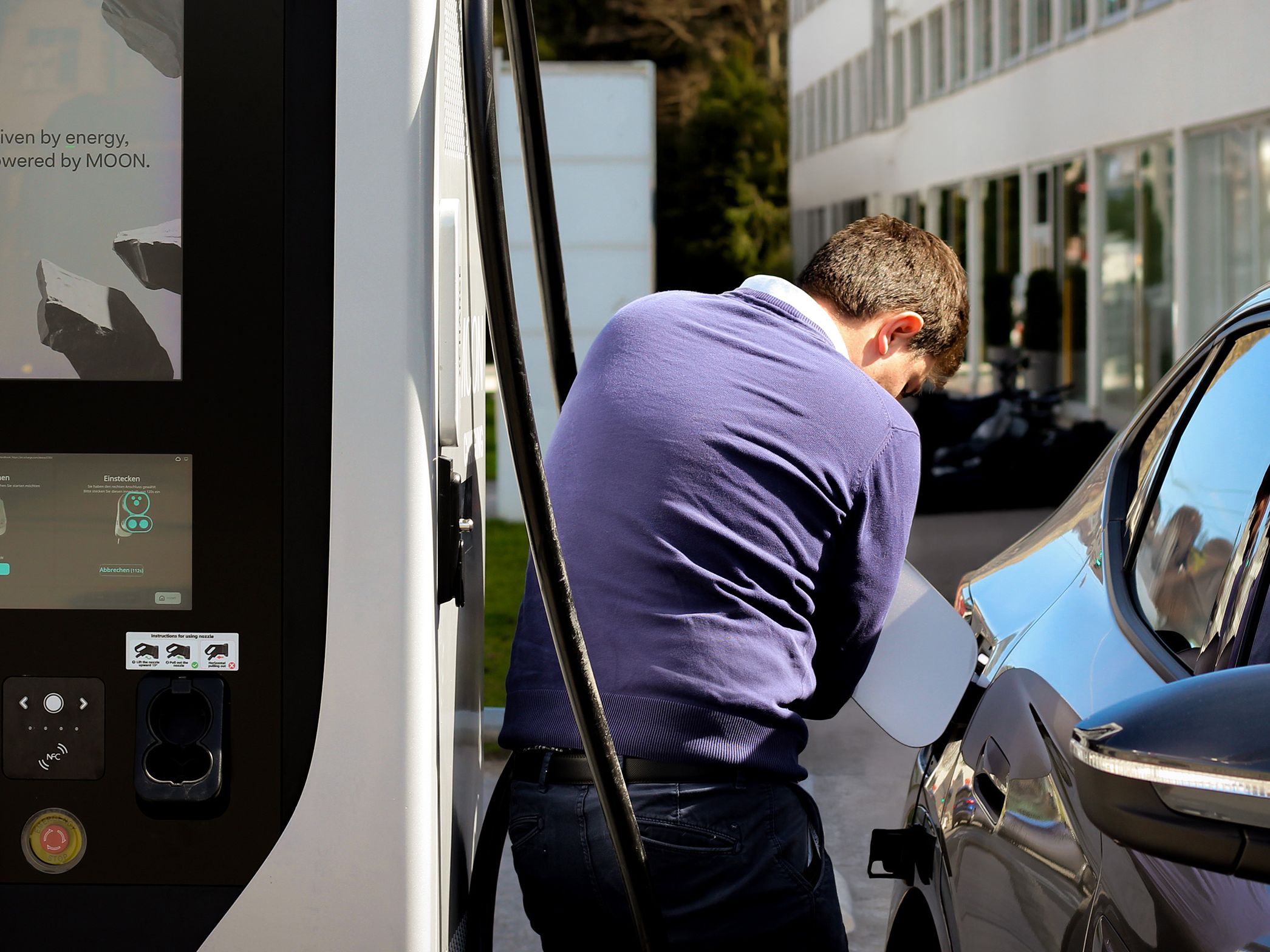 Un bărbat deschide capacul de combustibil al mașinii