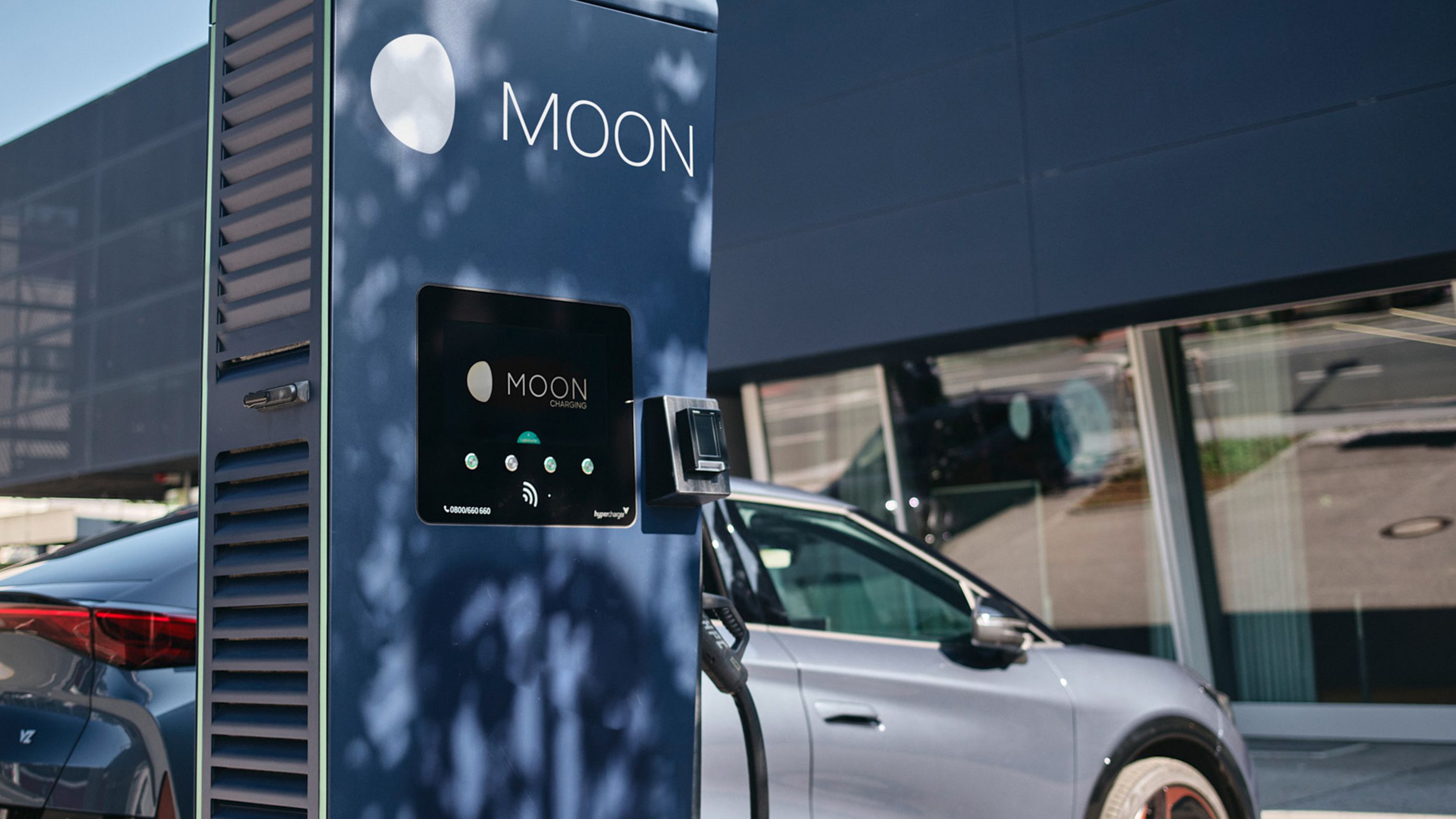 Stație de încărcare în fața unei mașini cu un ecran
