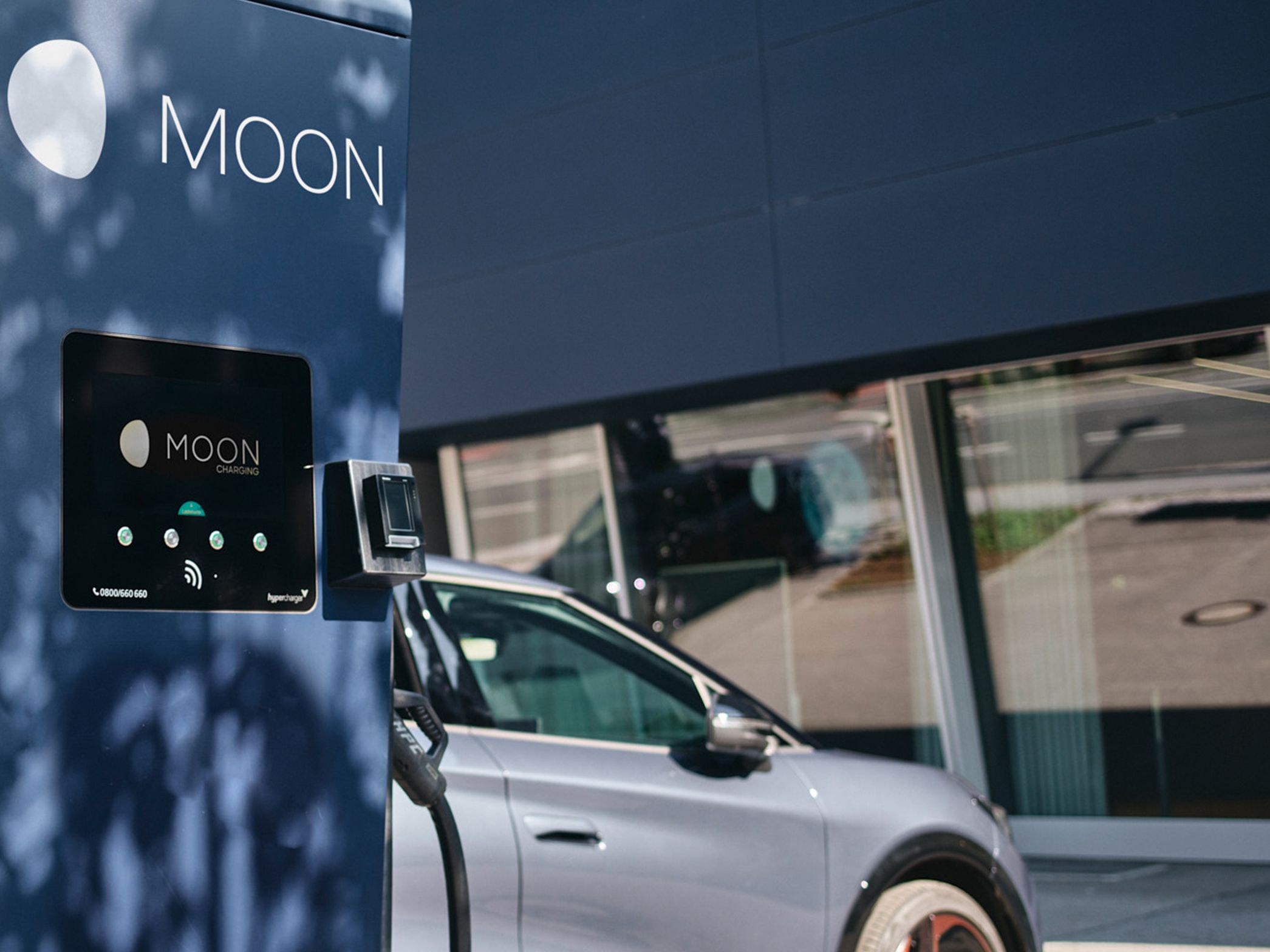 Stație de încărcare în fața unei mașini cu un ecran