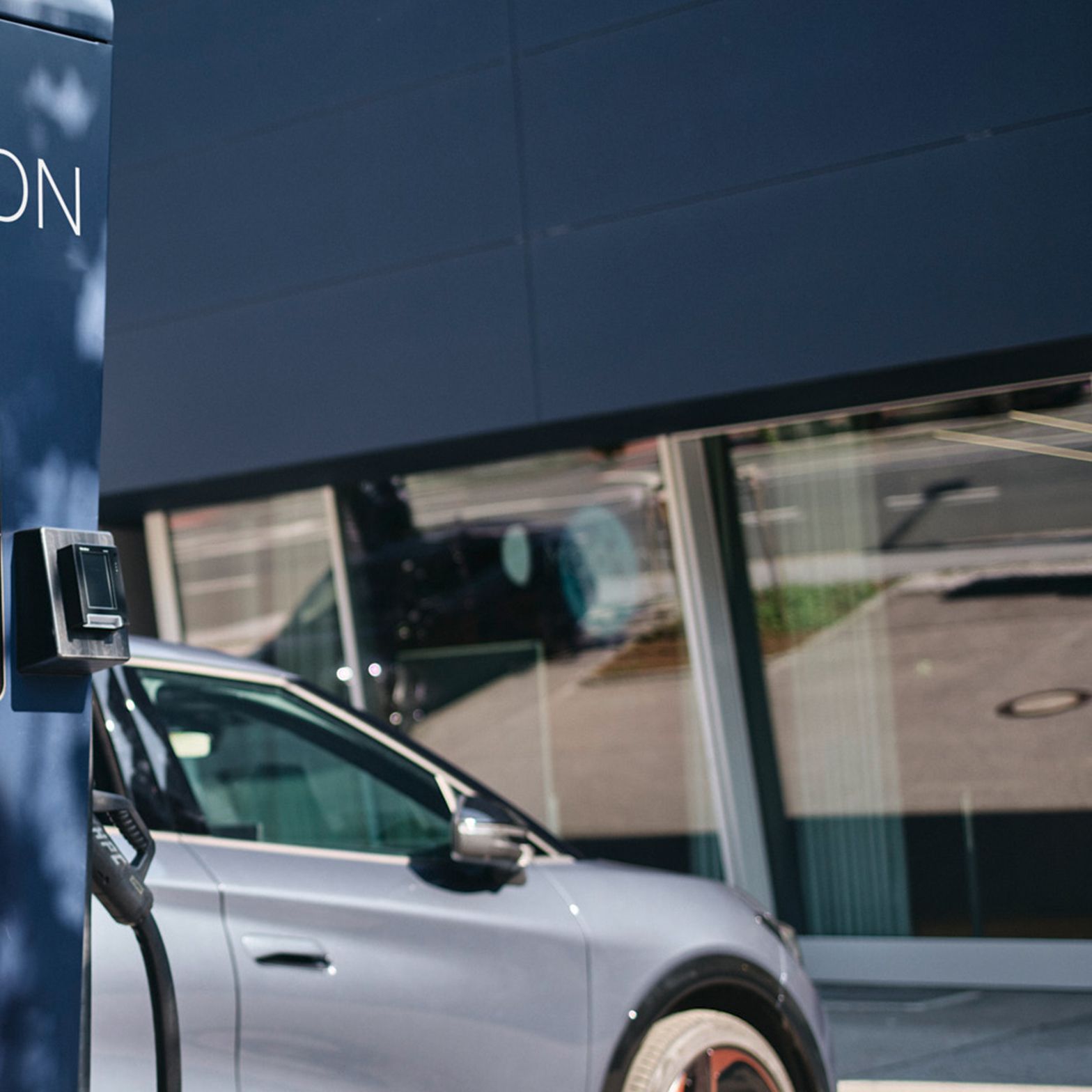 Stație de încărcare în fața unei mașini cu un ecran