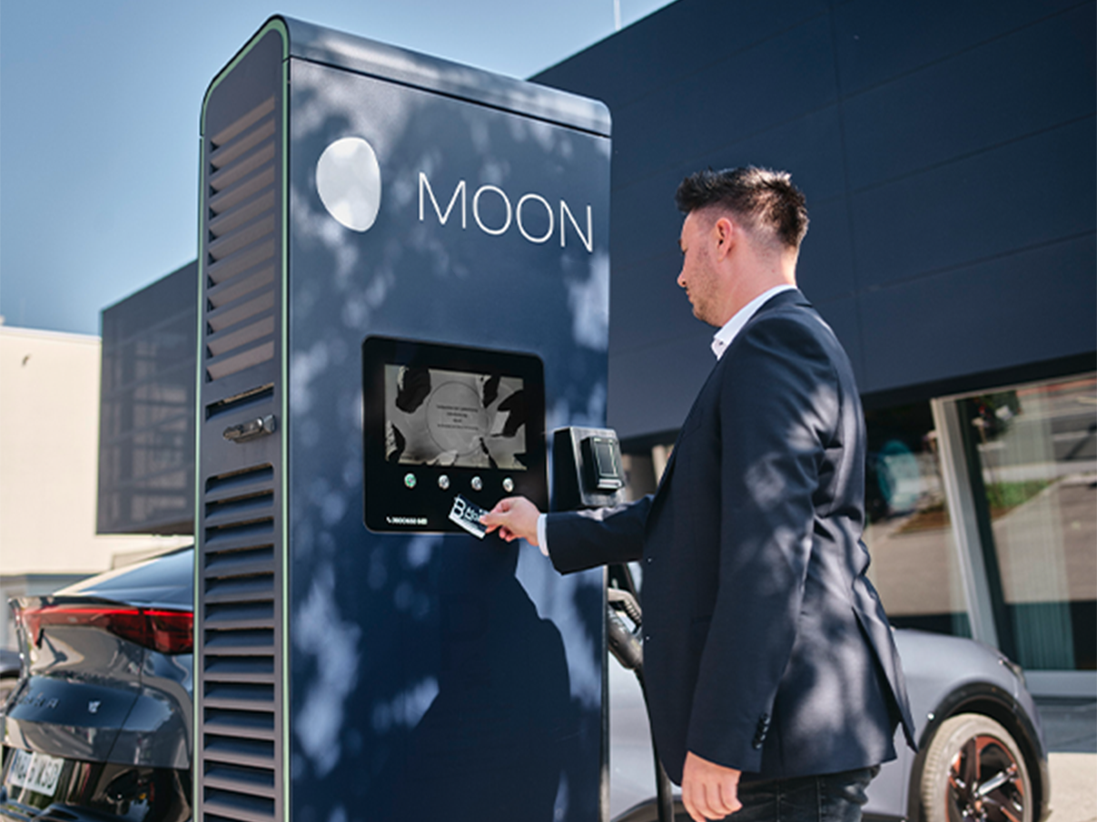 Cardul este ținut lângă afișajul unei stații de încărcare