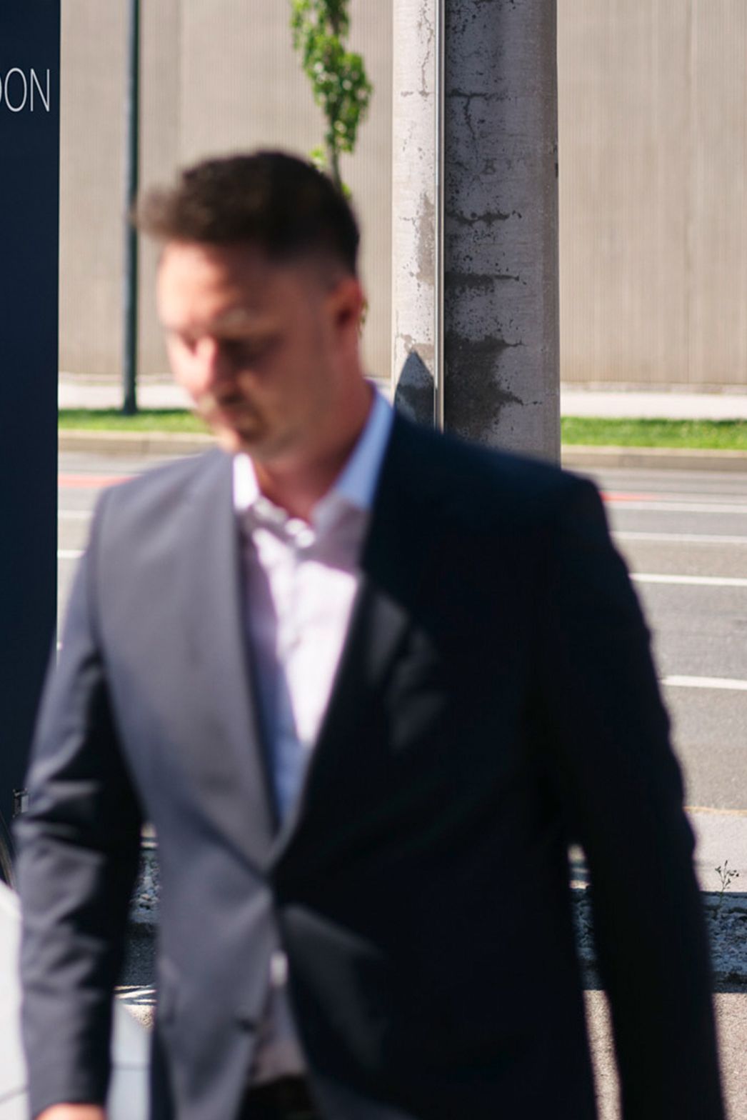 Bărbat merge în fața unei mașini în fața unei stații de încărcare